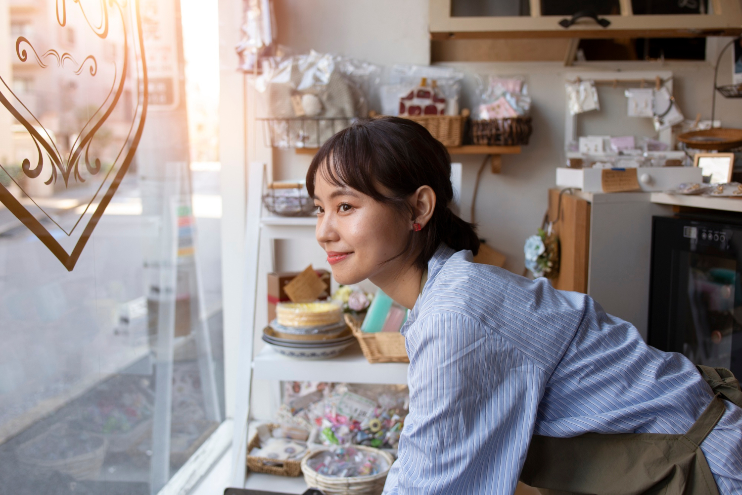 Young woman arranging items in her cake shop